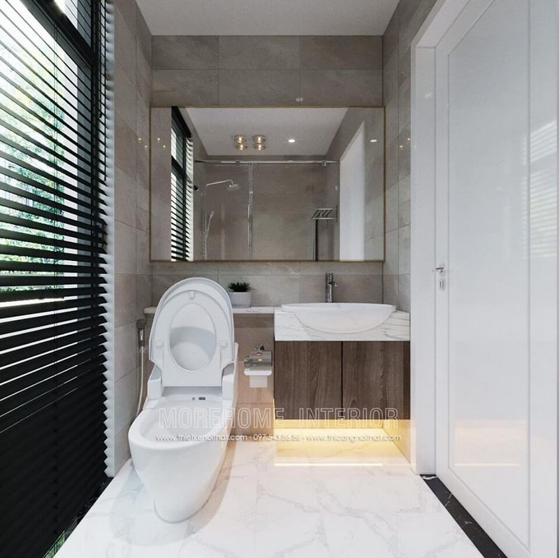 Mẫu gương trang điểm hình chữ nhật viền inox mạ vàng sắc sang trọng được đặt trong phòng tắm.
